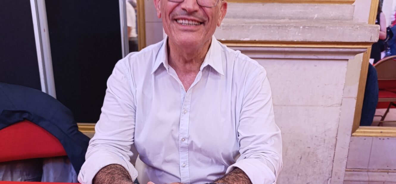 Toufik Hedna assis au stand des Éditions Hedna, lors du Maghreb des livres 2025 à Paris.